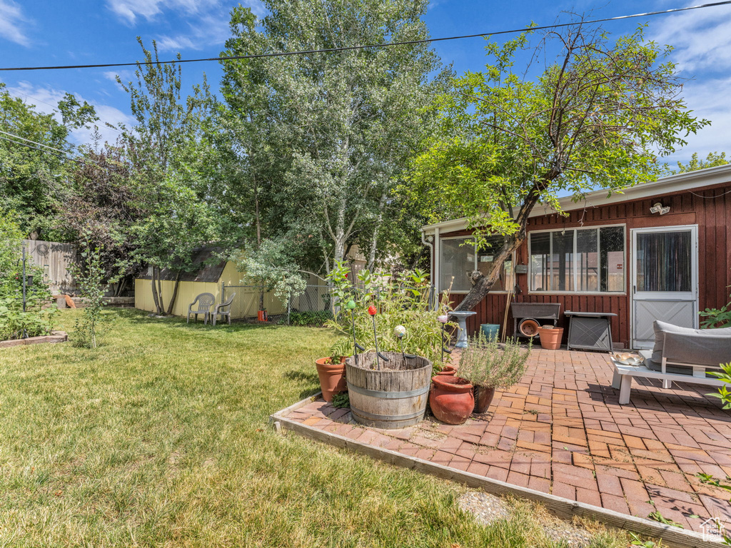 View of yard with a patio, a shed, and a sunroom