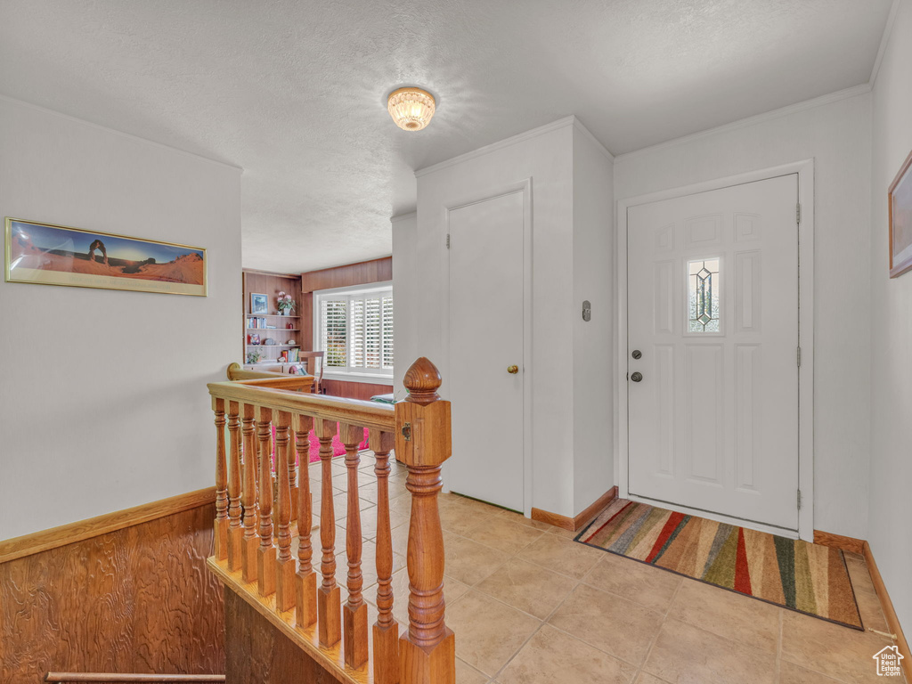 Foyer entrance with a textured ceiling and baseboards