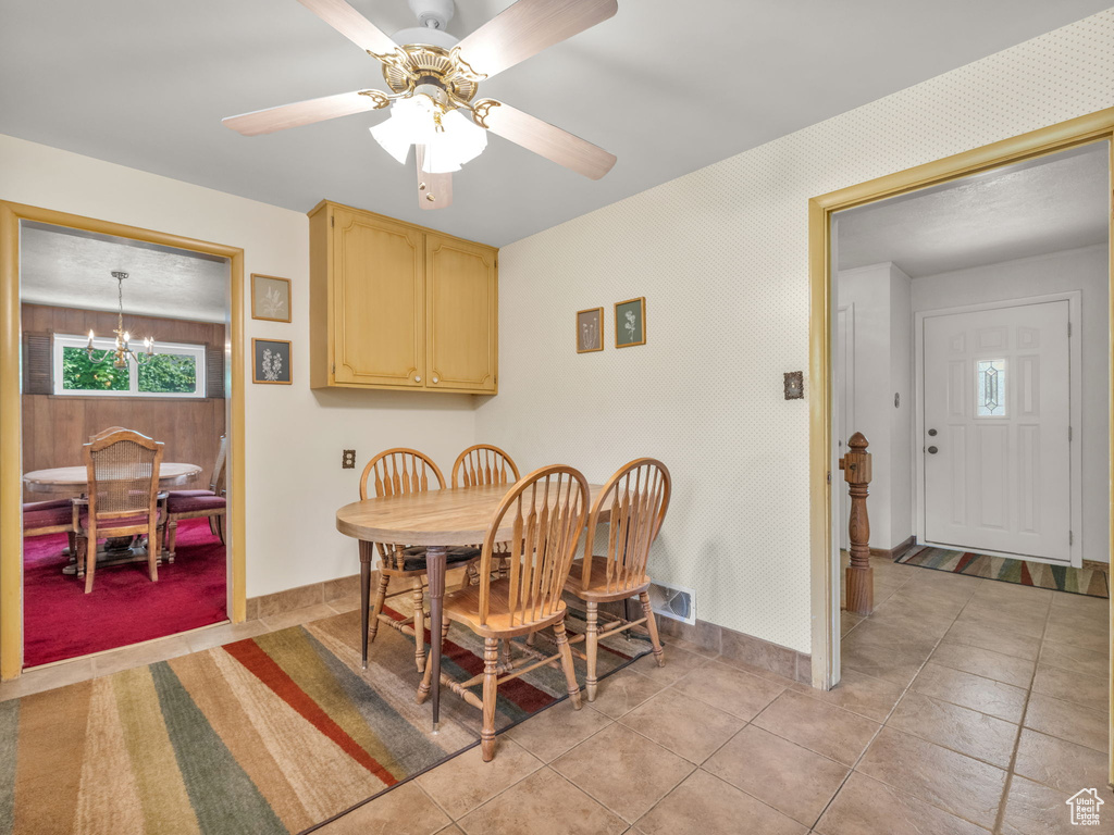 Dining space with a chandelier and ceiling fan