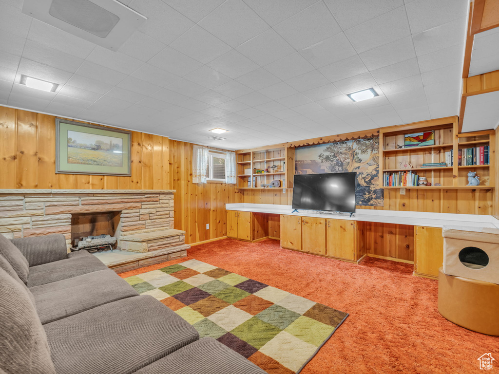Carpeted living room with wood walls