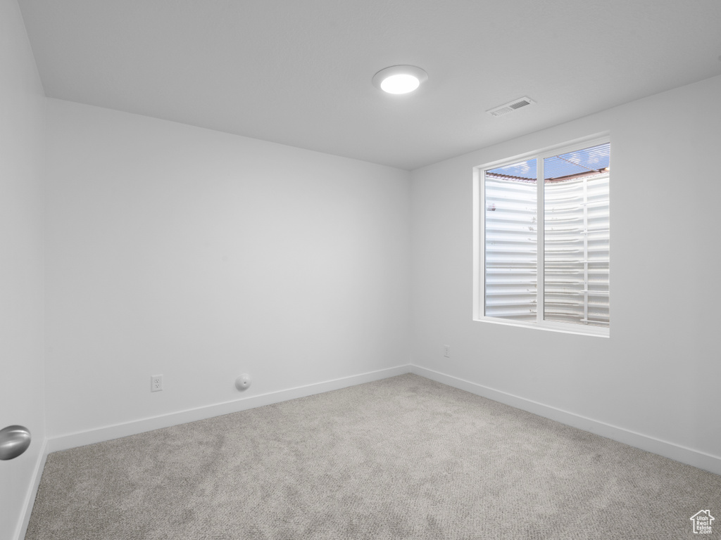 Carpeted empty room featuring baseboards
