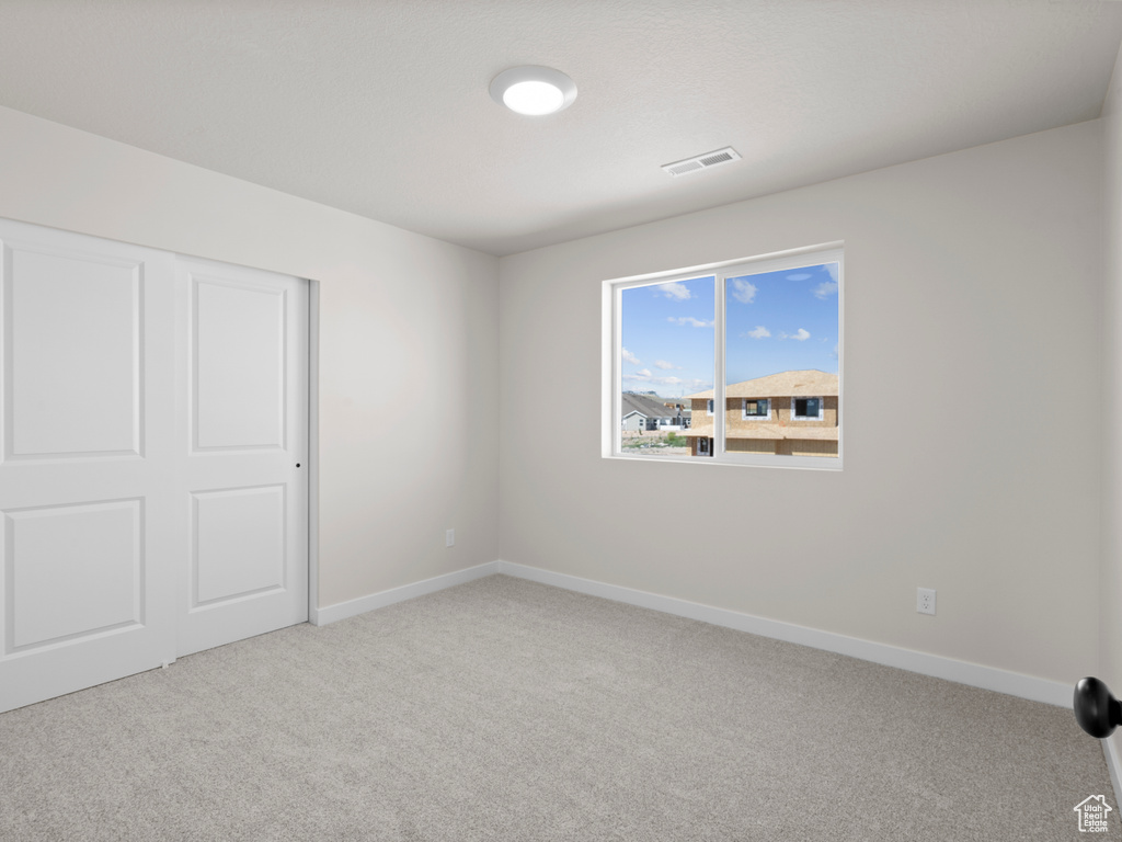 Unfurnished bedroom with carpet and a closet