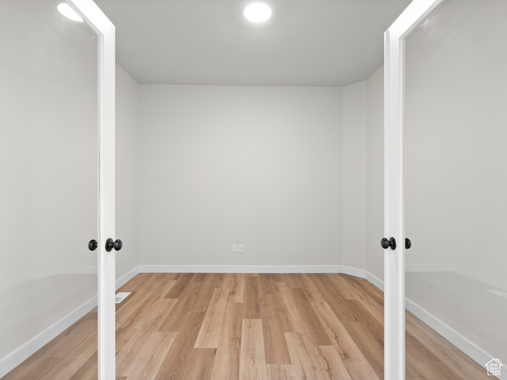 Empty room featuring french doors and light wood finished floors