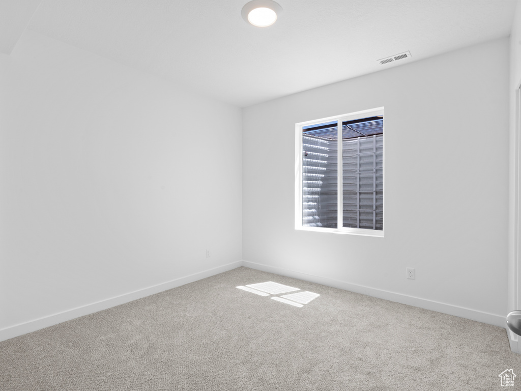 Empty room featuring carpet floors and baseboards