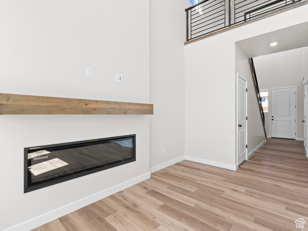 Unfurnished living room with wood finished floors and a glass covered fireplace