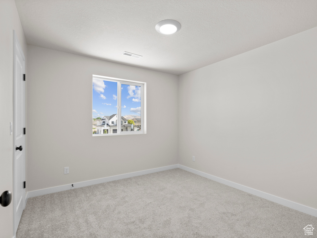 Carpeted spare room with baseboards