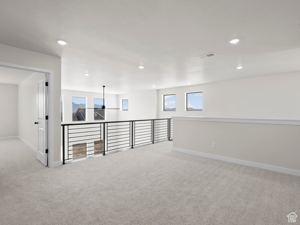 Carpeted empty room featuring baseboards and recessed lighting