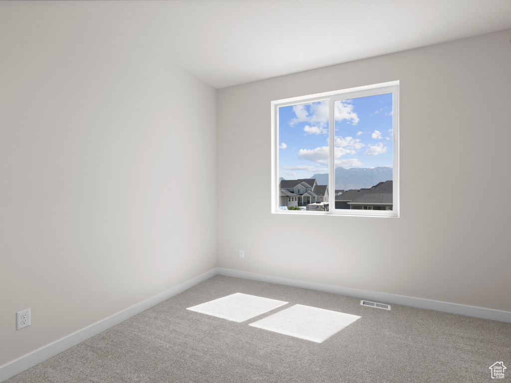 Carpeted empty room with baseboards