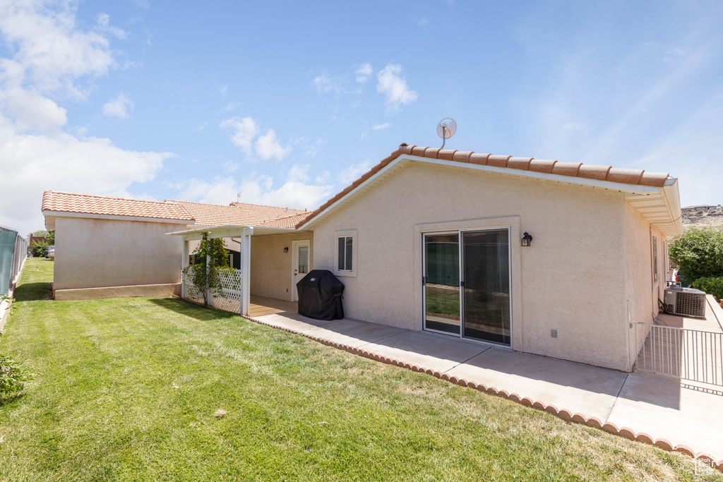 Rear view of property with a patio, stucco siding, and a lawn