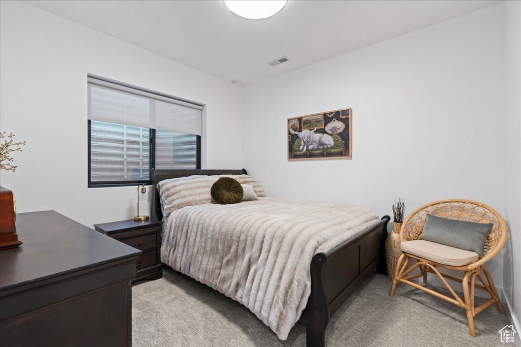 Bedroom featuring light carpet and a desk