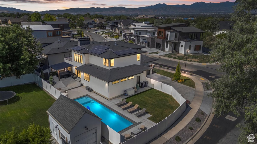 Aerial view of residential area featuring mountains and a pool