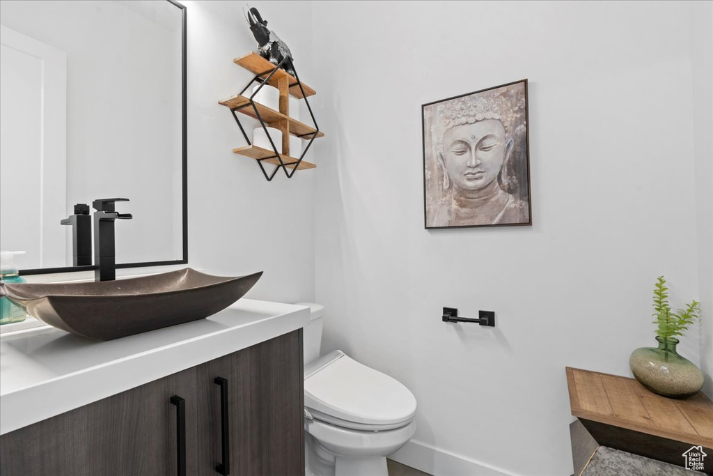 Half bath featuring toilet and vanity