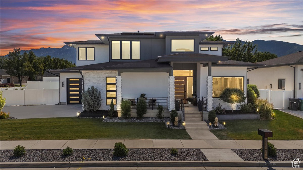 View of front of house featuring a mountain view, stucco siding, and driveway