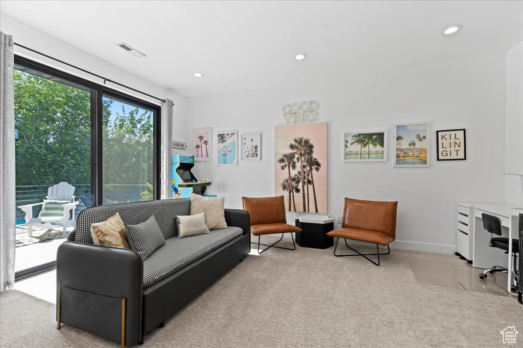 Carpeted living area featuring recessed lighting and baseboards