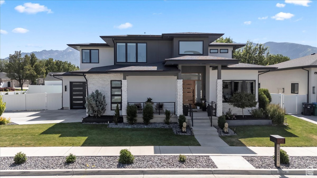 Prairie-style house featuring a mountain view, stucco siding, driveway, and a garage