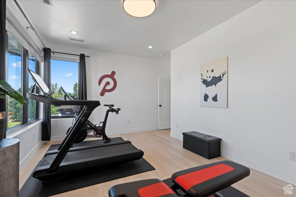 Exercise room featuring light wood-type flooring and recessed lighting