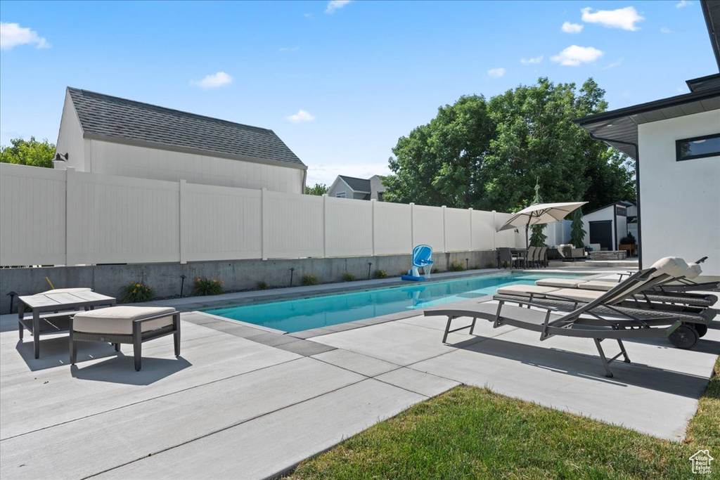 View of swimming pool with a fenced backyard and a patio