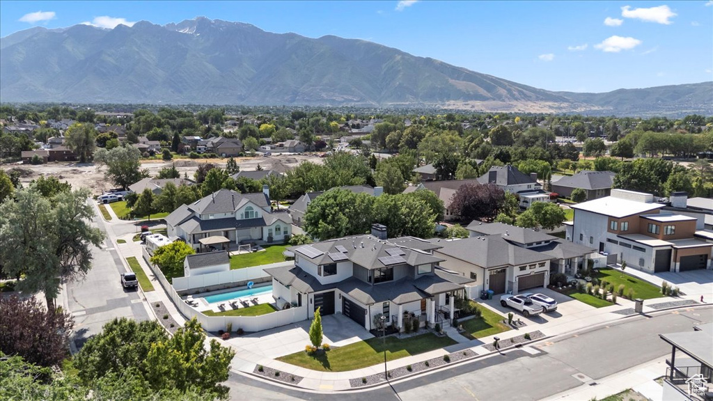 Aerial perspective of suburban area featuring a mountain backdrop and a pool