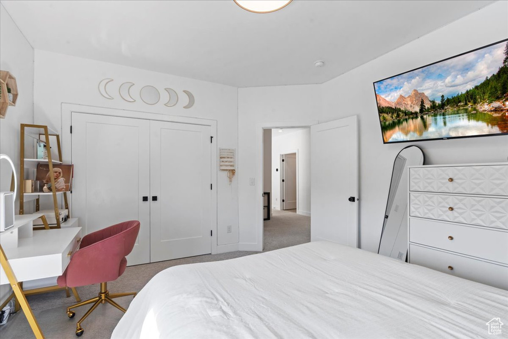 Carpeted bedroom featuring a closet and baseboards