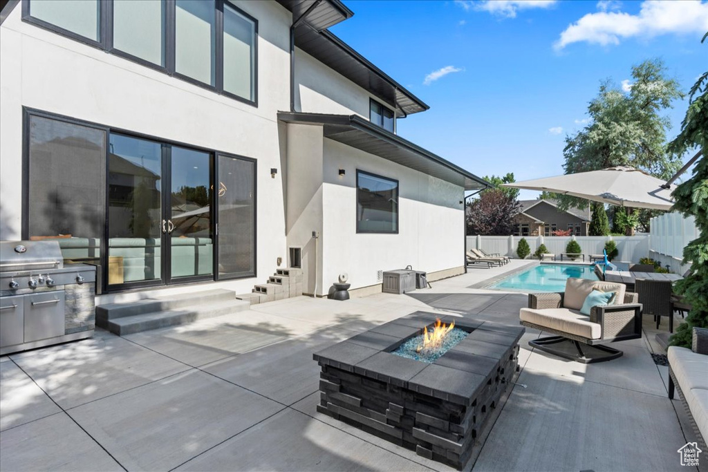 View of patio with a fire pit, area for grilling, and entry steps
