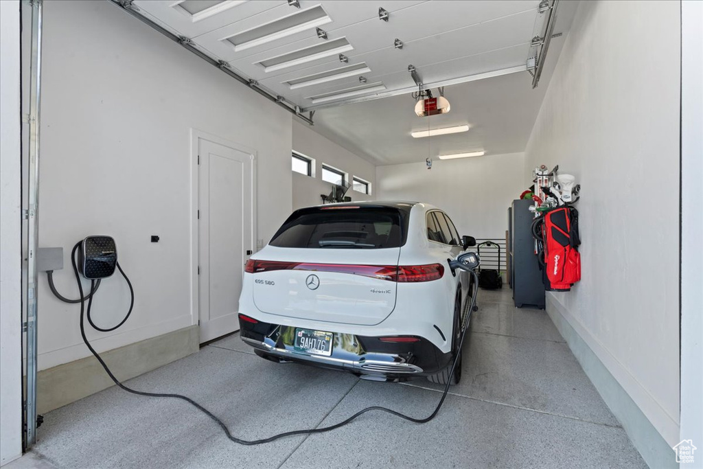 Garage featuring a garage door opener and fridge