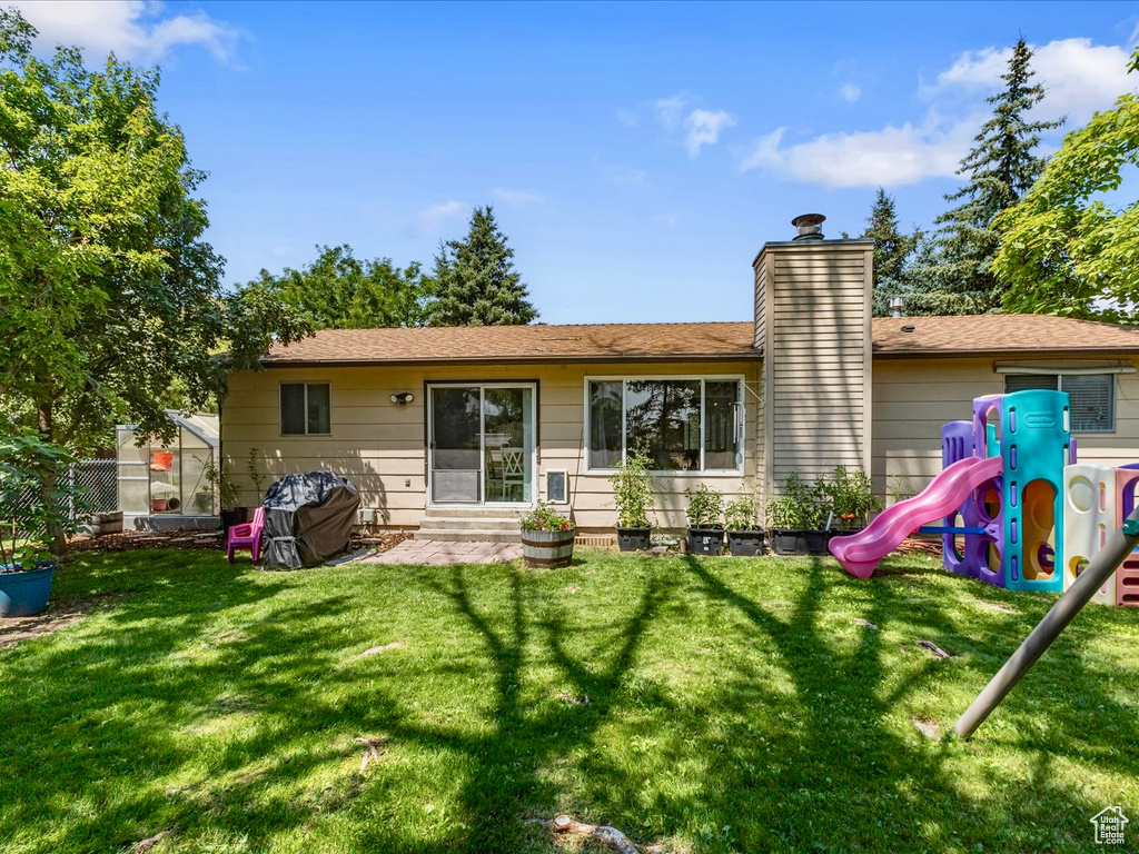 Back of property with a playground and a chimney