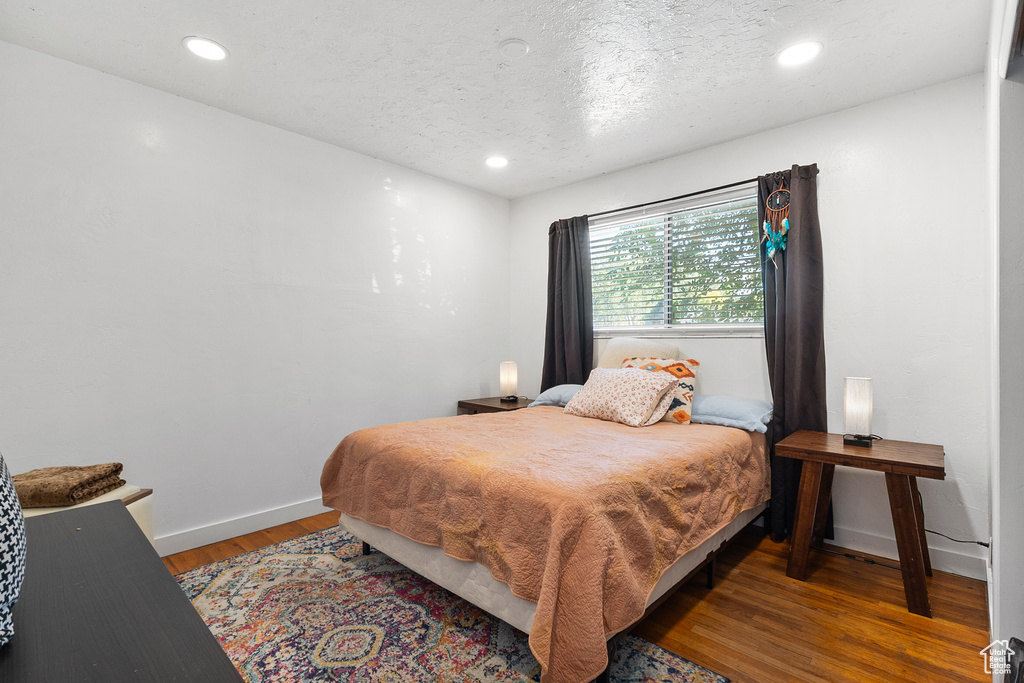 Bedroom featuring wood finished floors, recessed lighting, and a textured ceiling