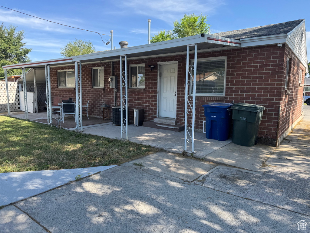View of front of property featuring brick siding and a patio