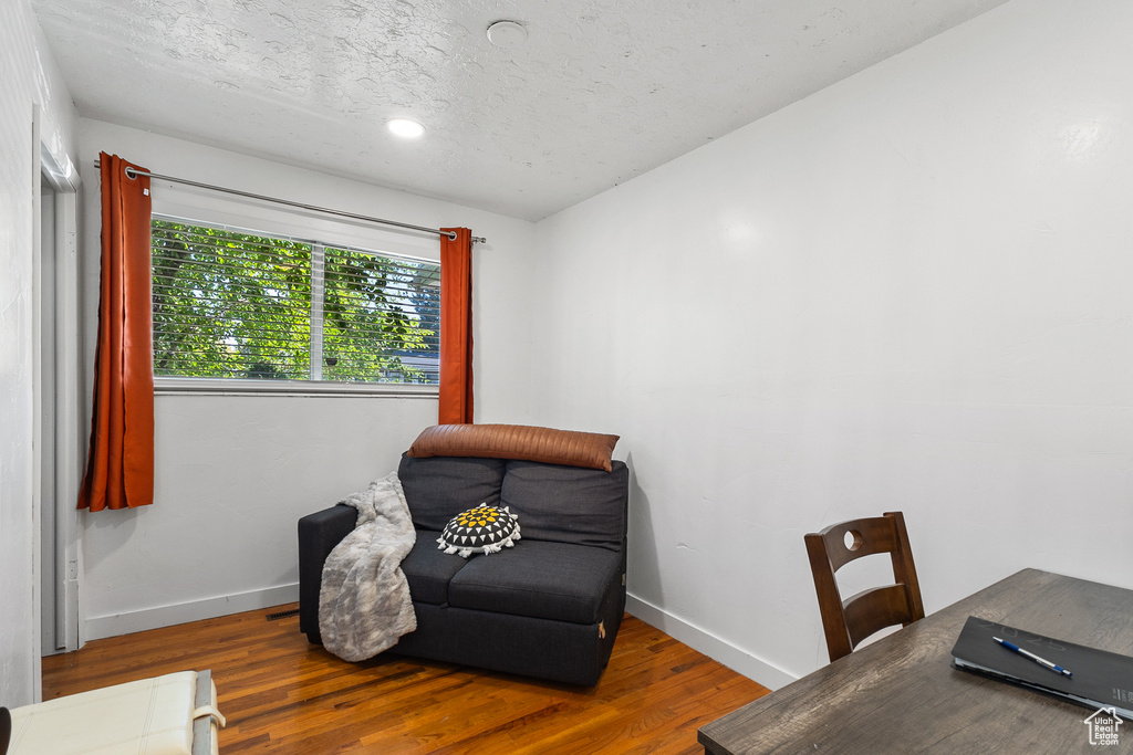 Sitting room with wood finished floors and a textured ceiling