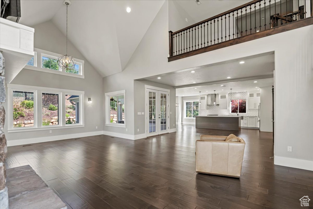 Living area featuring french doors, dark wood finished floors, high vaulted ceiling, and plenty of natural light