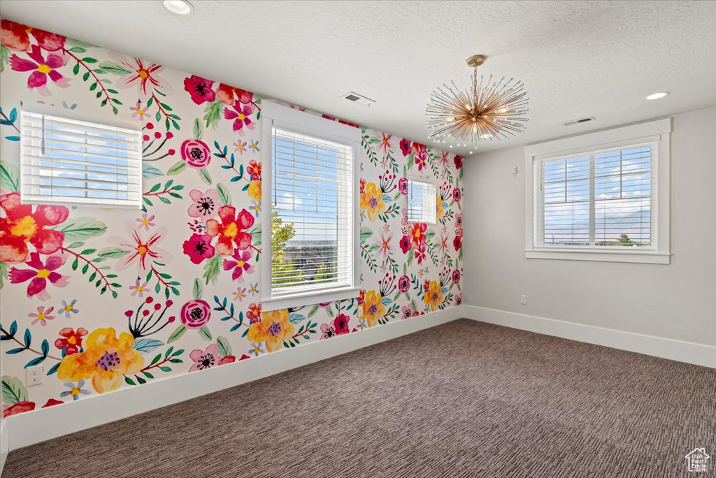 Carpeted empty room featuring wallpapered walls, a textured ceiling, plenty of natural light, and recessed lighting