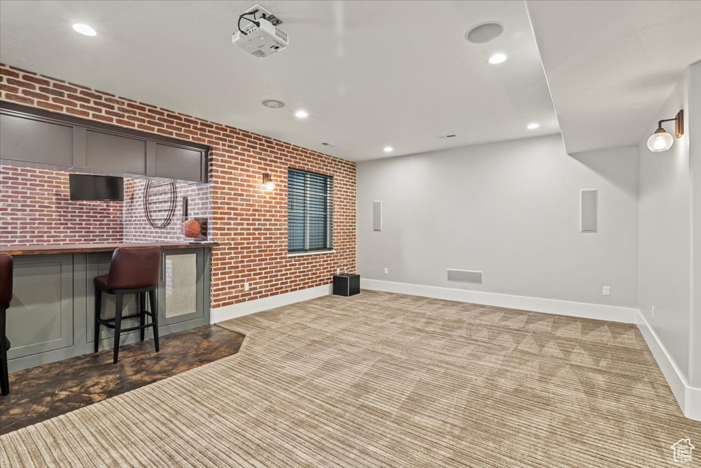 Basement with brick wall, carpet, and recessed lighting