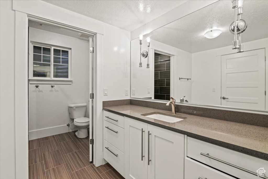 Bathroom with a textured ceiling and vanity