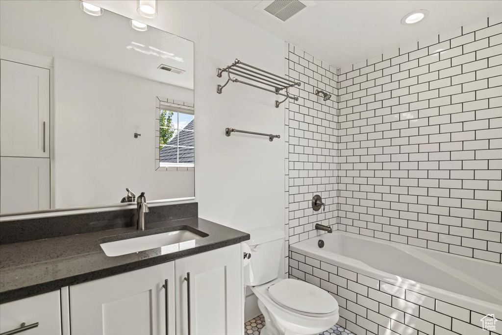 Full bathroom featuring vanity, tiled shower / bath, and recessed lighting