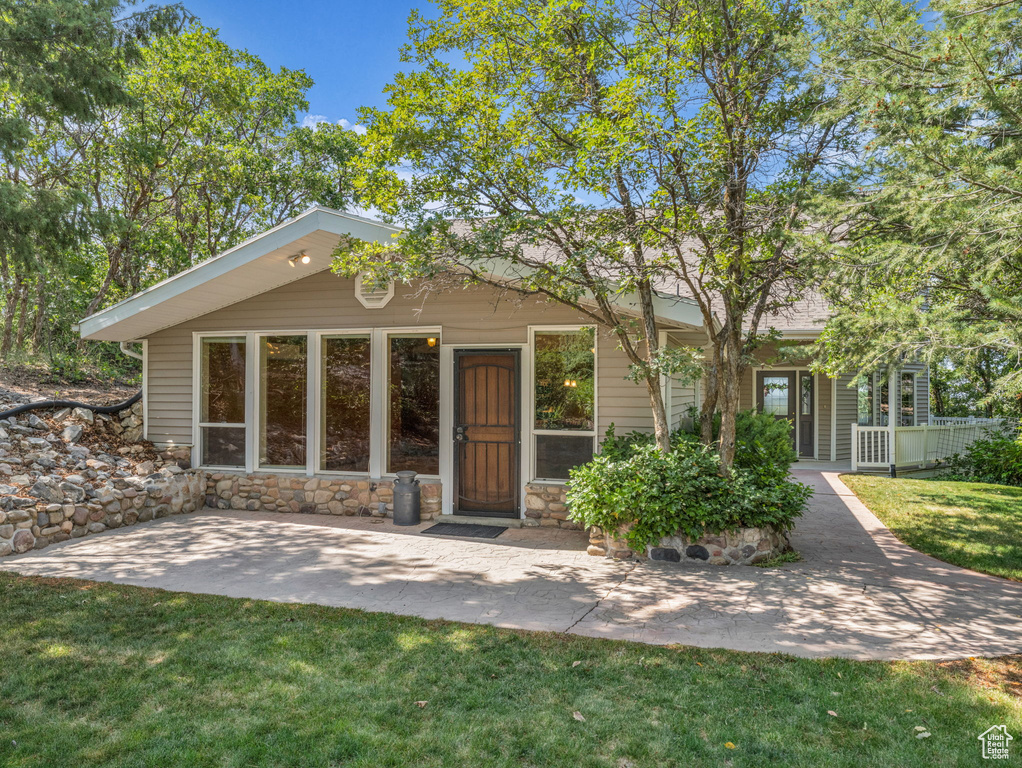 View of front of home featuring stone siding and a front lawn
