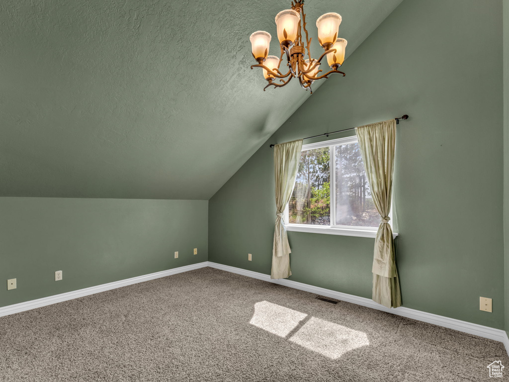 Additional living space featuring vaulted ceiling, a chandelier, a textured ceiling, and carpet floors