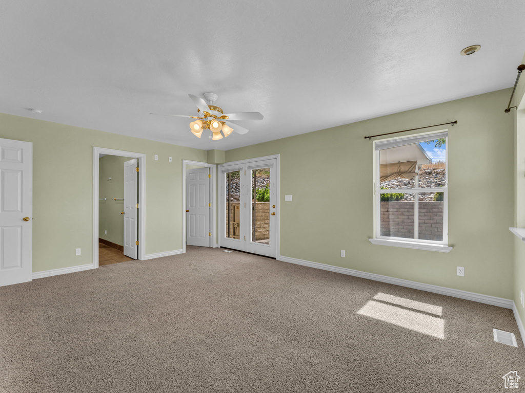 Unfurnished bedroom featuring carpet flooring, access to outside, a ceiling fan, and ensuite bathroom