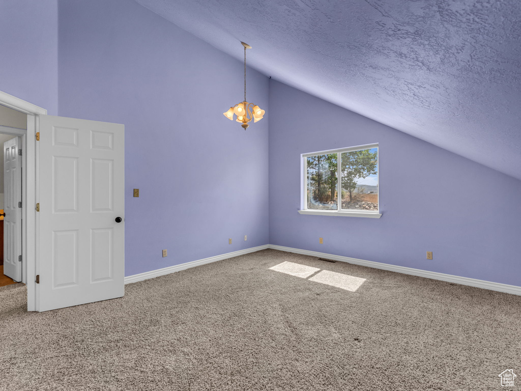 Bonus room featuring carpet, a chandelier, a textured ceiling, and high vaulted ceiling