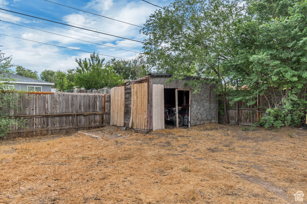 Fenced backyard featuring a storage unit
