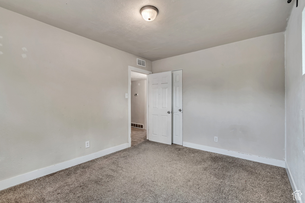Carpeted empty room with baseboards