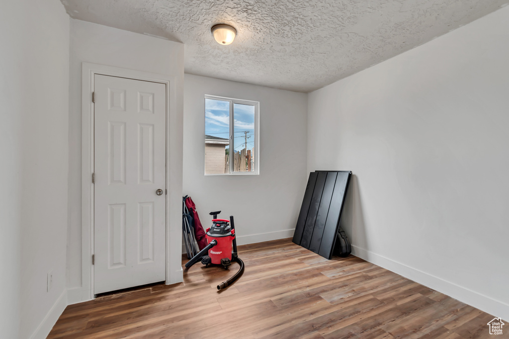 Unfurnished bedroom featuring light wood finished floors and a textured ceiling