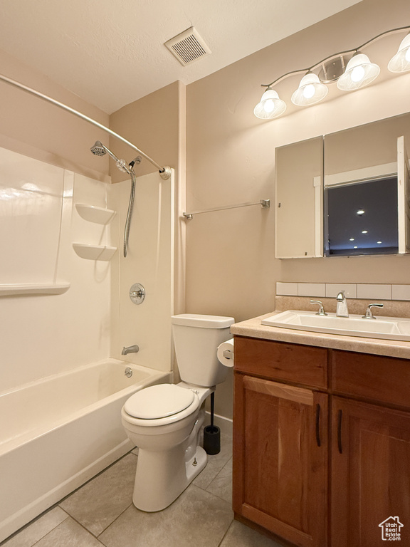 Bathroom featuring tile patterned flooring, vanity, and tub / shower combination