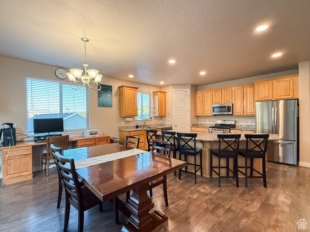 Dining space featuring dark wood-type flooring, a chandelier, recessed lighting, and a textured ceiling
