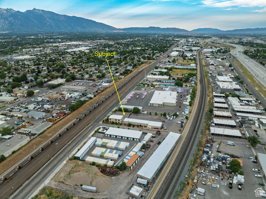 Aerial view of property and surrounding area featuring a major roadway and mountains