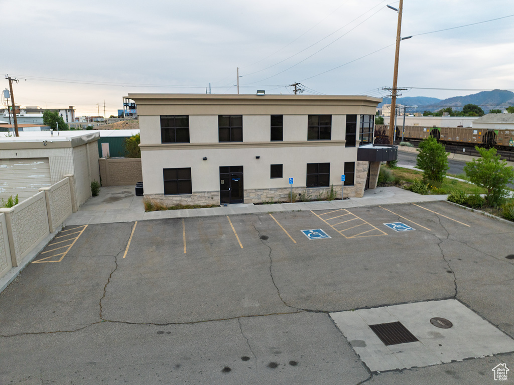 View of building exterior with a mountain view and uncovered parking