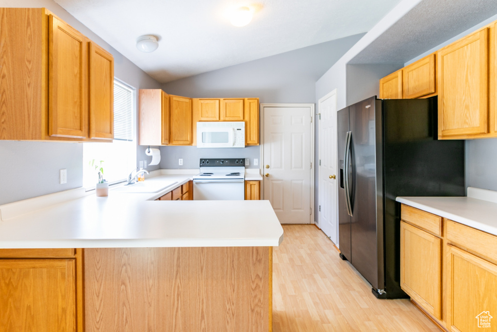Kitchen with white appliances, light countertops, light wood-style floors, a peninsula, and lofted ceiling