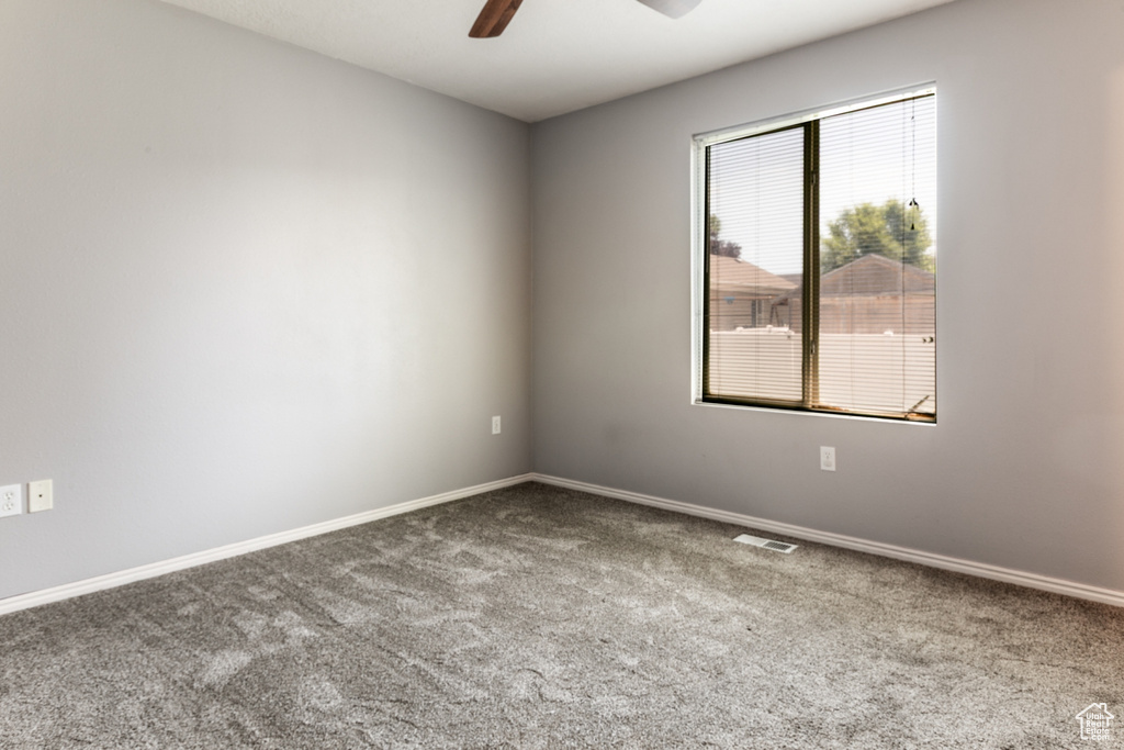 Unfurnished room featuring carpet and a ceiling fan