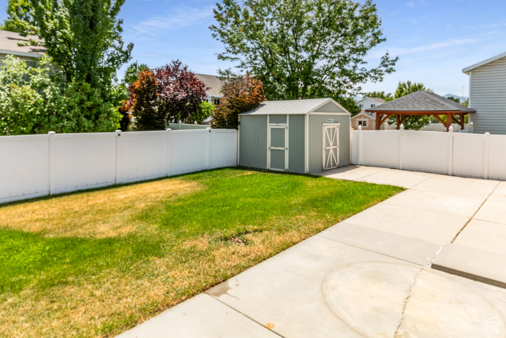 Fenced backyard with a gazebo, a patio, and a shed