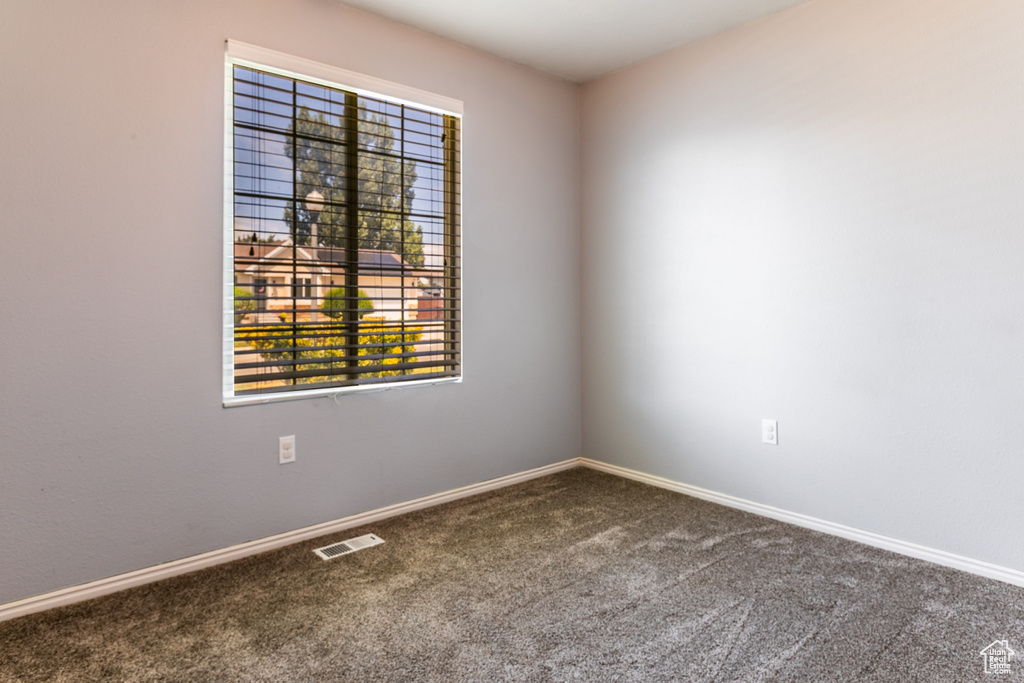 Unfurnished room featuring carpet and baseboards