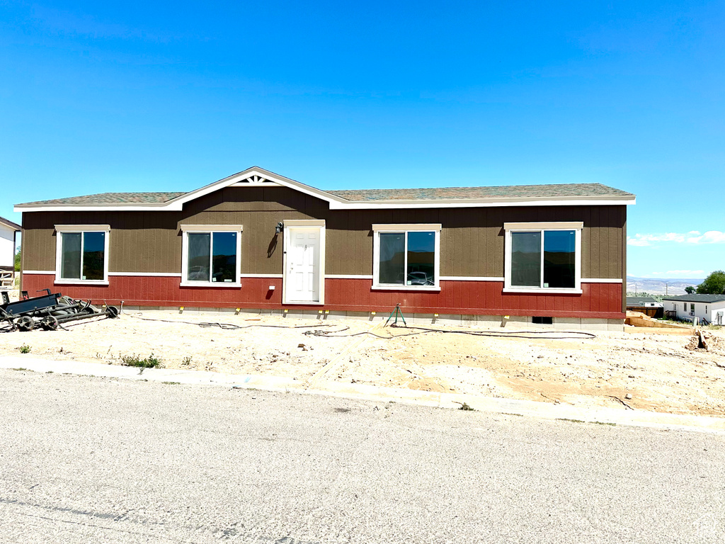 View of front of property with crawl space and a shingled roof
